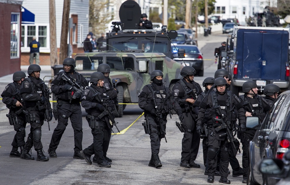 Heavily armed police continue to patrol the neighborhoods of Watertown, Mass. Friday, April 19, 2013, as they continue a massive search for one of two suspects in the Boston Marathon bombing. A second suspect died in the early morning hours after an encounter with law enforcement. (AP Photo/Craig Ruttle)